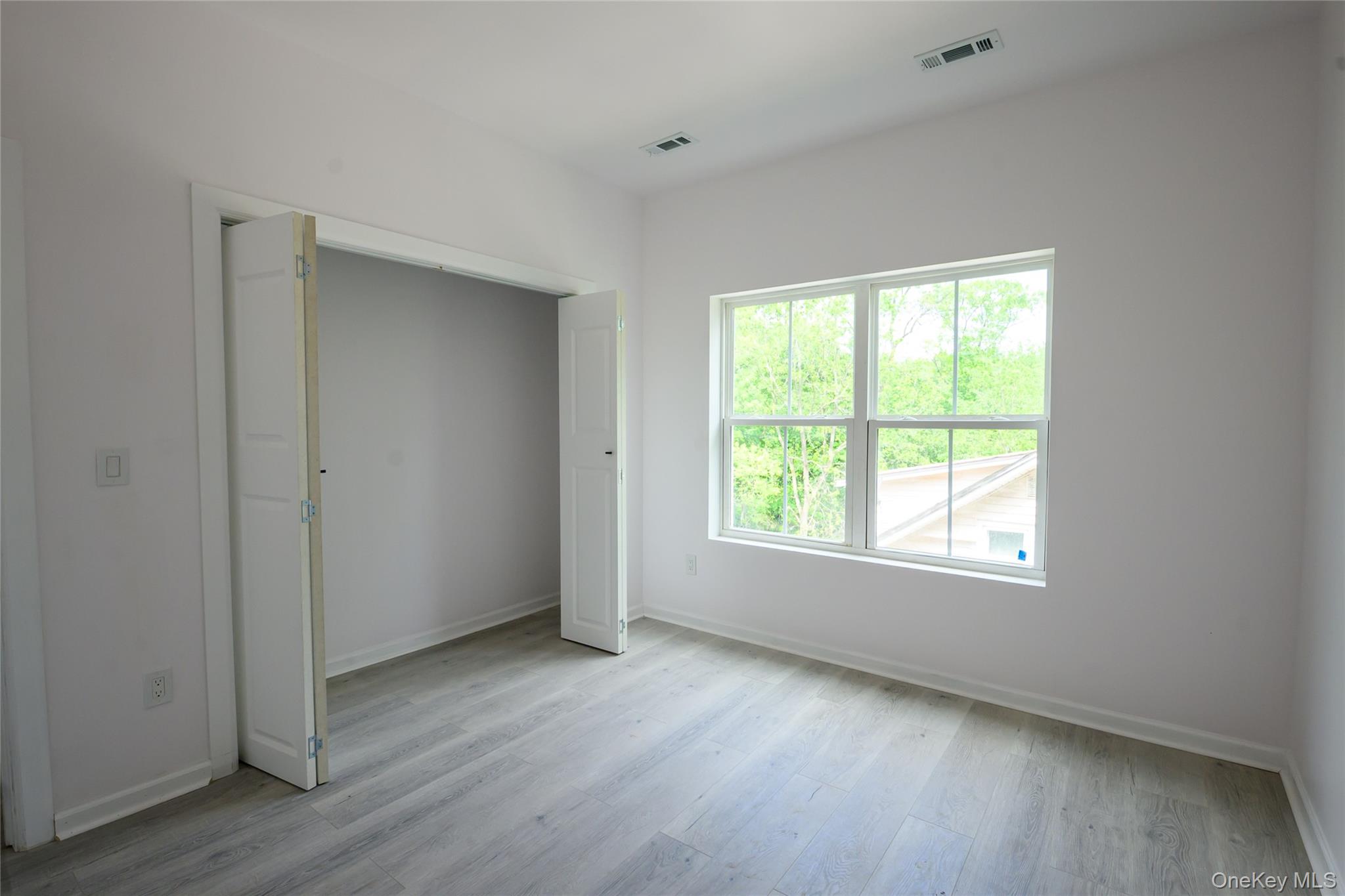 81 Silver Lake Sctn Road Middletown, NY 10940 - Photo 25 of 37 an empty room with wooden floor and windows