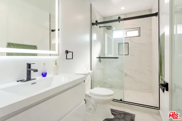 a bathroom with a sink toilet and shower