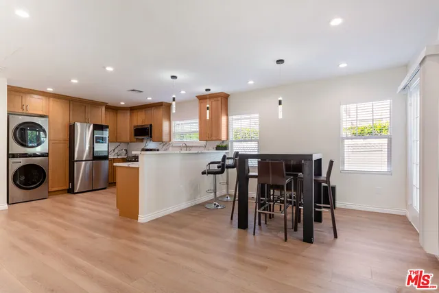 a view of kitchen with stainless steel appliances granite countertop a table and chairs in it