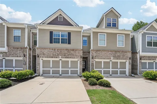 a front view of a house with yard and parking