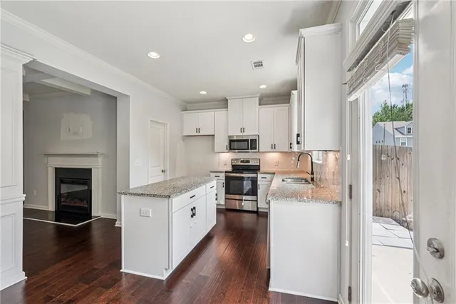 a kitchen with cabinets and wooden floor