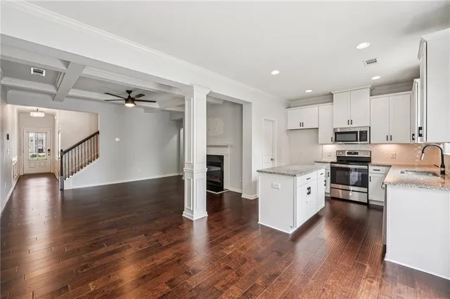 a kitchen with granite countertop stainless steel appliances and wooden floor