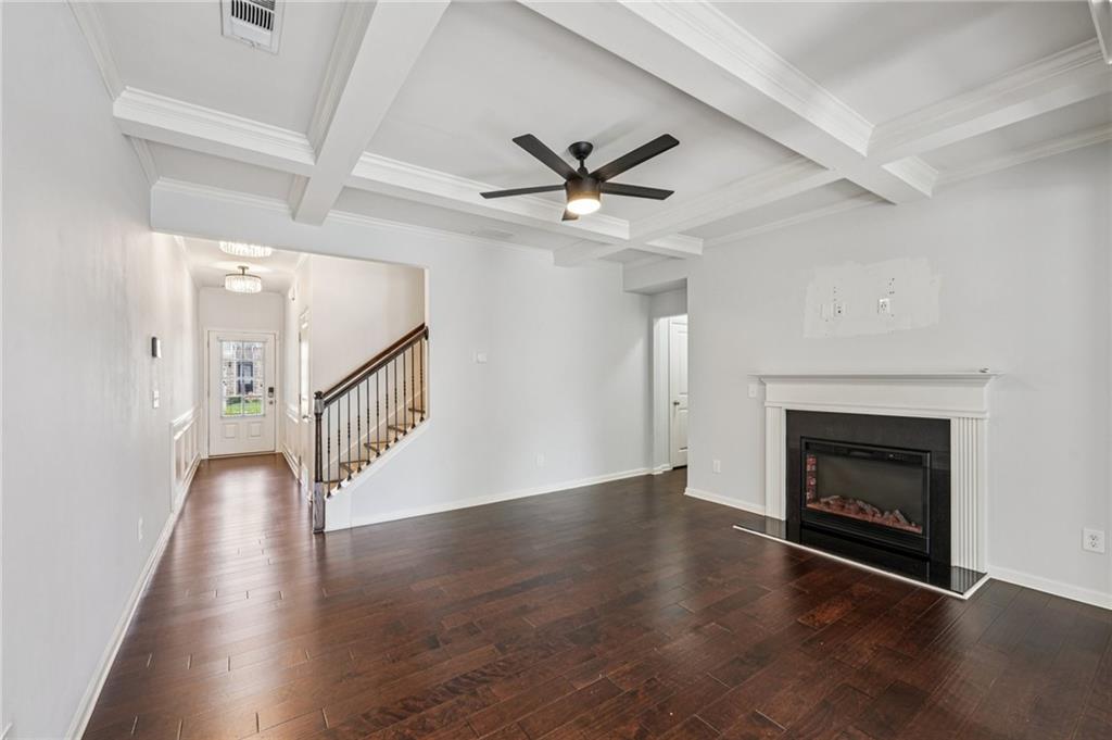 208 Trailside Way Hiram, GA 30141 - Photo 9 of 45 an empty room with wooden floor a fireplace and a ceiling fan