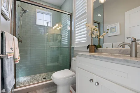 a bathroom with a toilet sink vanity and mirror