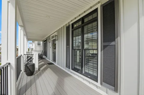 a living room with furniture a flat screen tv and kitchen view