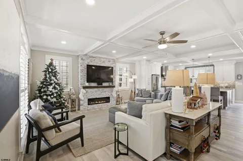 a kitchen with stainless steel appliances kitchen island granite countertop a refrigerator a stove a sink a dining table and chairs with wooden floor