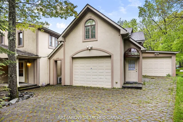 an aerial view of a house with a yard and a large tree