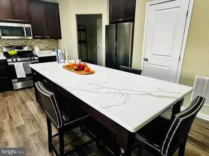 a kitchen with a kitchen island a stove a table and chairs