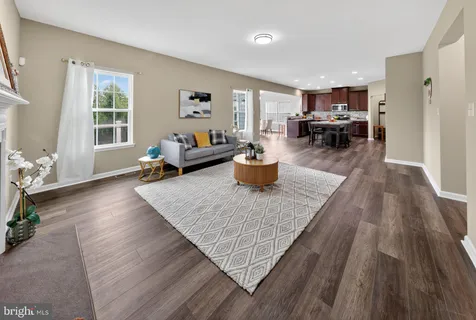 a large white kitchen with lots of counter space wooden floor and stainless steel appliances
