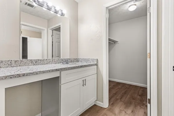 a bathroom with a granite countertop sink and a mirror