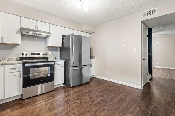 a kitchen with a refrigerator and a stove top oven