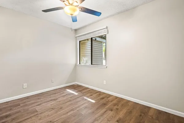 an empty room with wooden floor and windows