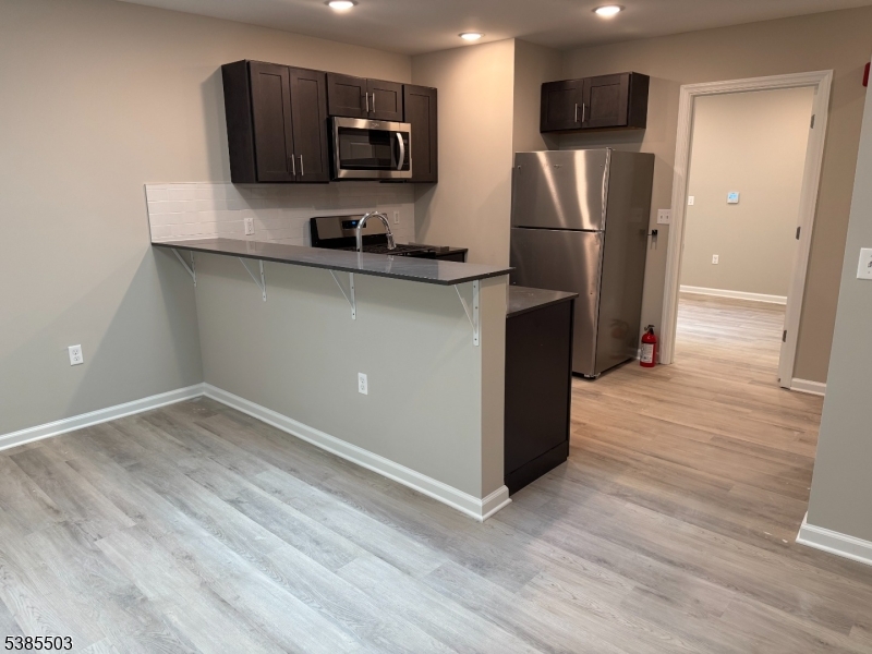 10 East Washington Avenue, Unit 302 Washington, NJ 07882 - Photo 2 of 4 a kitchen with stainless steel appliances a refrigerator microwave and sink