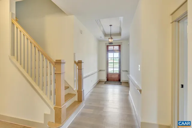 a view of a hallway with wooden floor and stairs
