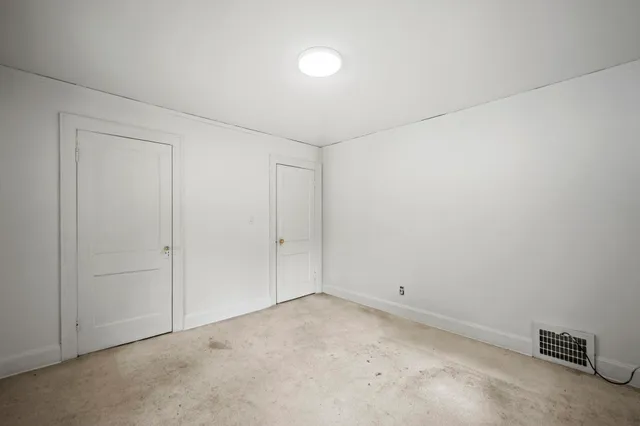 a bathroom with a granite countertop toilet a sink a mirror and a shower