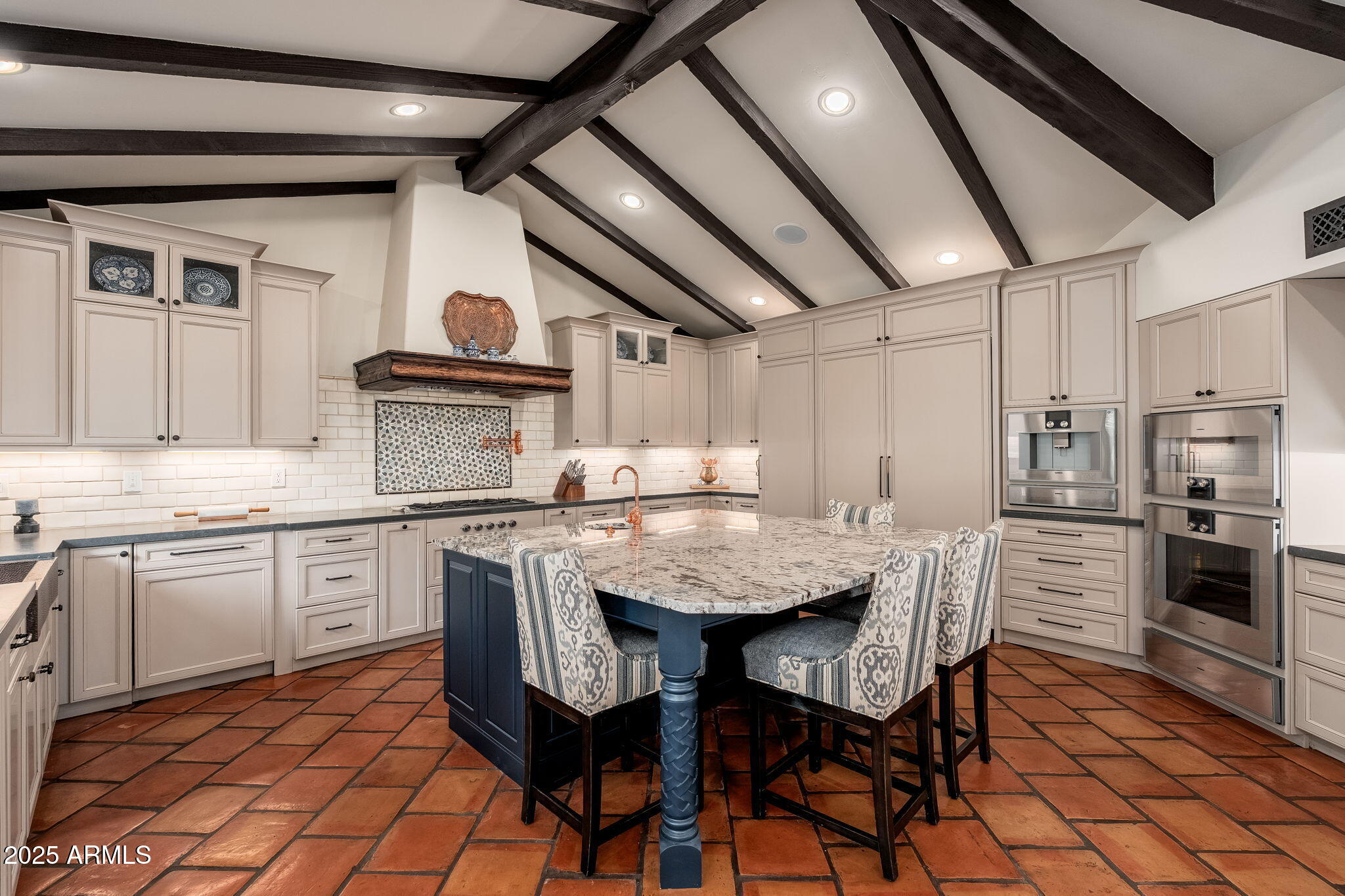 6527 East El Sendero Road Carefree, AZ 85377 - Photo 24 of 93 a kitchen with stainless steel appliances granite countertop a stove a sink dishwasher a dining table and chairs with wooden floor