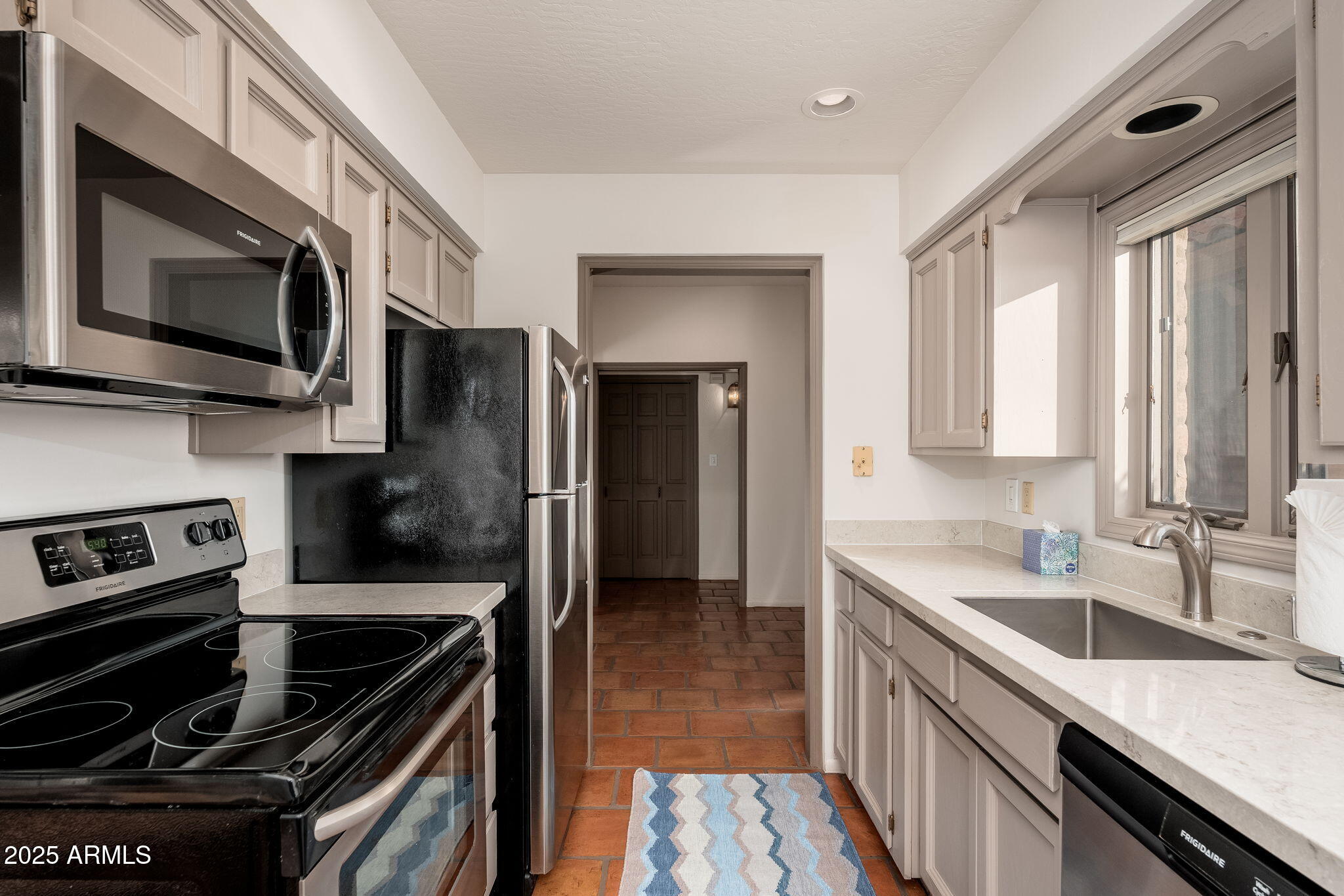 6527 East El Sendero Road Carefree, AZ 85377 - Photo 79 of 93 a kitchen with stainless steel appliances granite countertop a stove microwave and sink