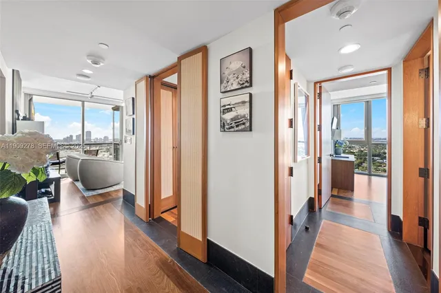 a view of a hallway with wooden floor and furniture