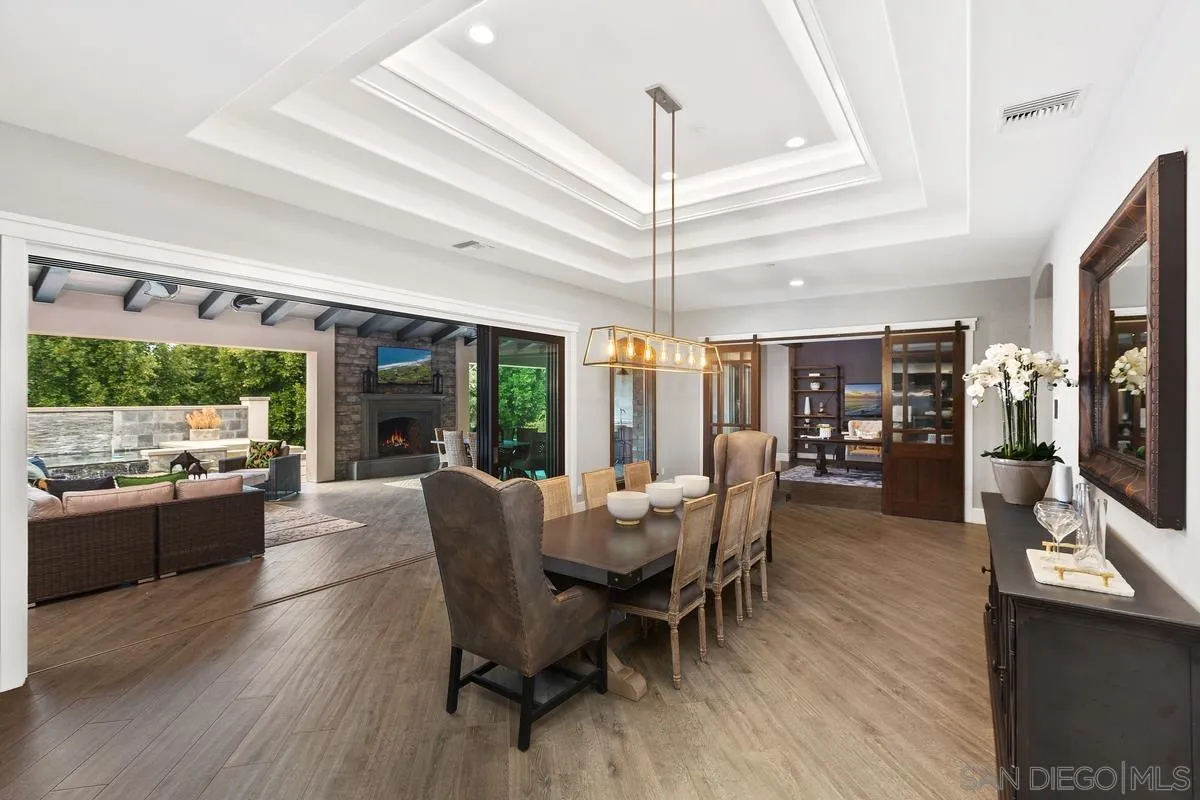 8330 Artesian Road San Diego, CA 92127 - Photo 6 of 26 a dining room with furniture a chandelier and wooden floor
