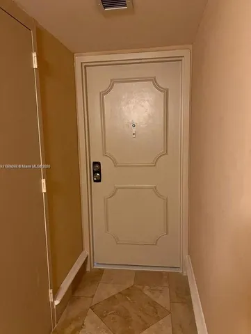 a hallway with potted plants and white walls