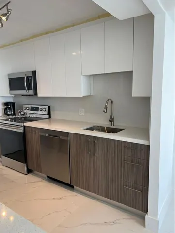 a kitchen with stainless steel appliances a refrigerator and a sink