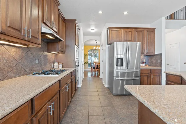 a kitchen with stainless steel appliances granite countertop a stove and a refrigerator