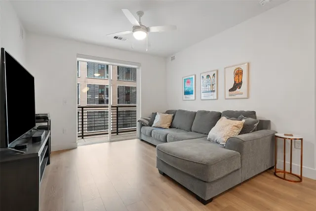 a living room with furniture a flat screen tv and a window