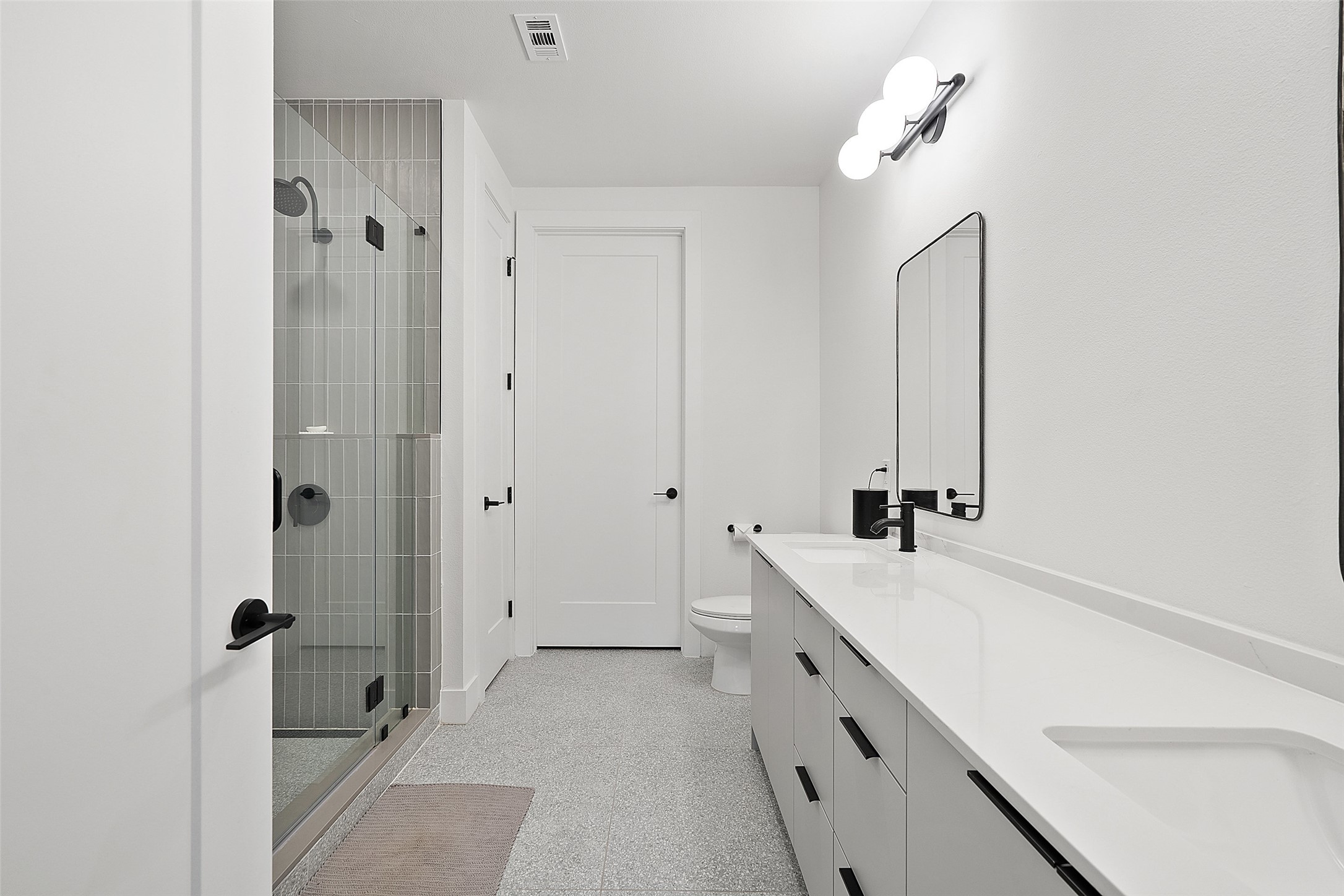 1701 Simond Avenue, Unit 305 Austin, TX 78723 - Photo 8 of 31 a bathroom with a double vanity sink a mirror and a bathtub