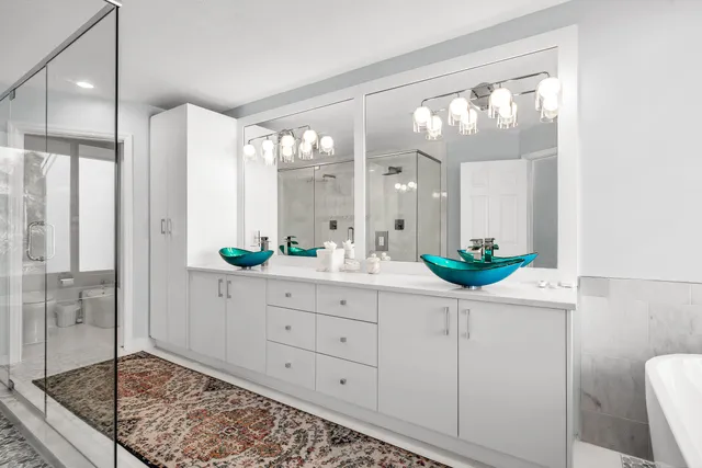 a bathroom with a double vanity sink mirror and shower