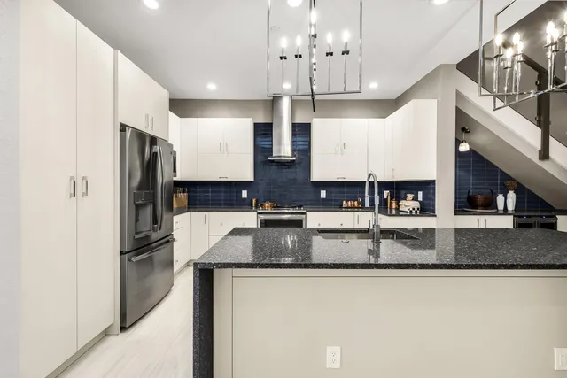 a kitchen with stainless steel appliances granite countertop a sink refrigerator and cabinets