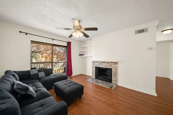 a living room with furniture a fireplace and a large window