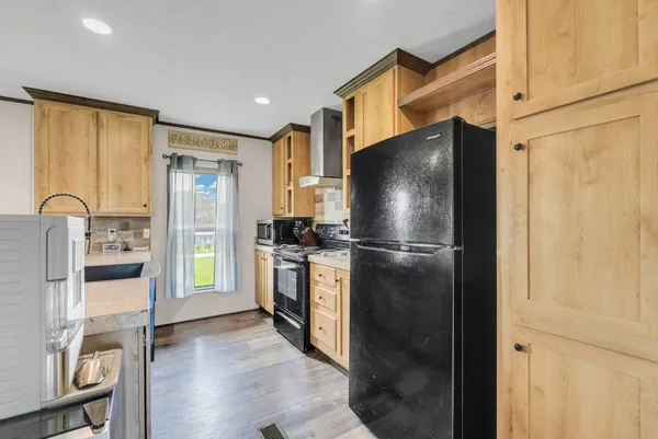a kitchen with a refrigerator and a stove top oven