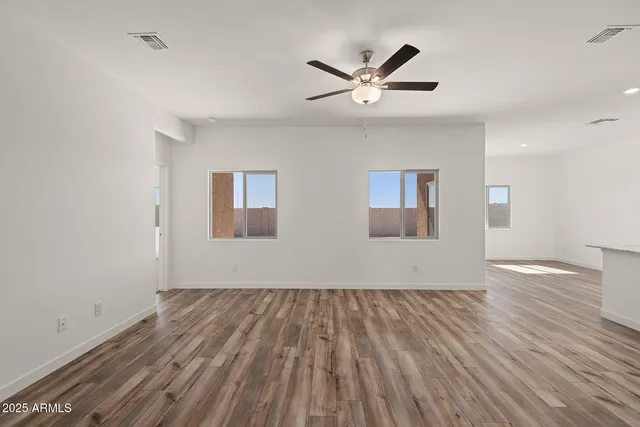 a view of empty room with wooden floor and window
