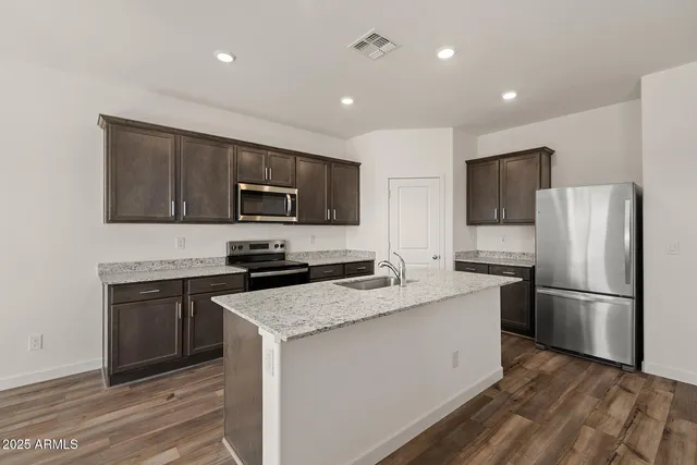 a kitchen with a sink a microwave a refrigerator and cabinets