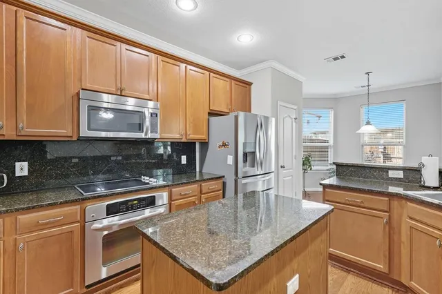 a kitchen with stainless steel appliances granite countertop a sink stove and refrigerator