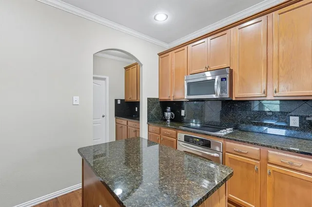 a kitchen with stainless steel appliances granite countertop a stove a sink and a microwave