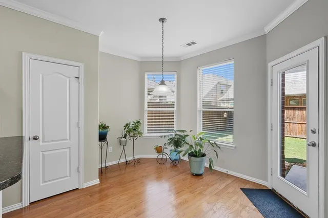 a view of a hallway with wooden floor and a potted plant