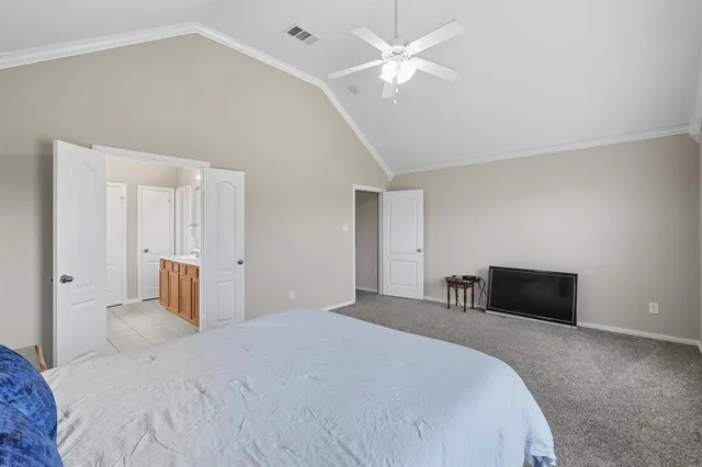 a bedroom with a large bed and a chandelier