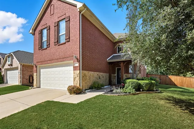 a front view of a house with a yard and trees
