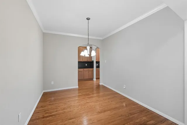 a view of a room with wooden floor chandelier and entryway