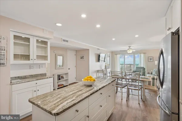 a kitchen with granite countertop a stove a sink and a refrigerator