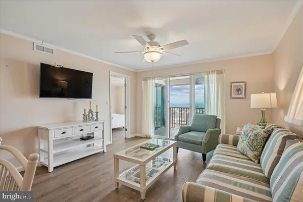 a living room with furniture a flat screen tv and a window