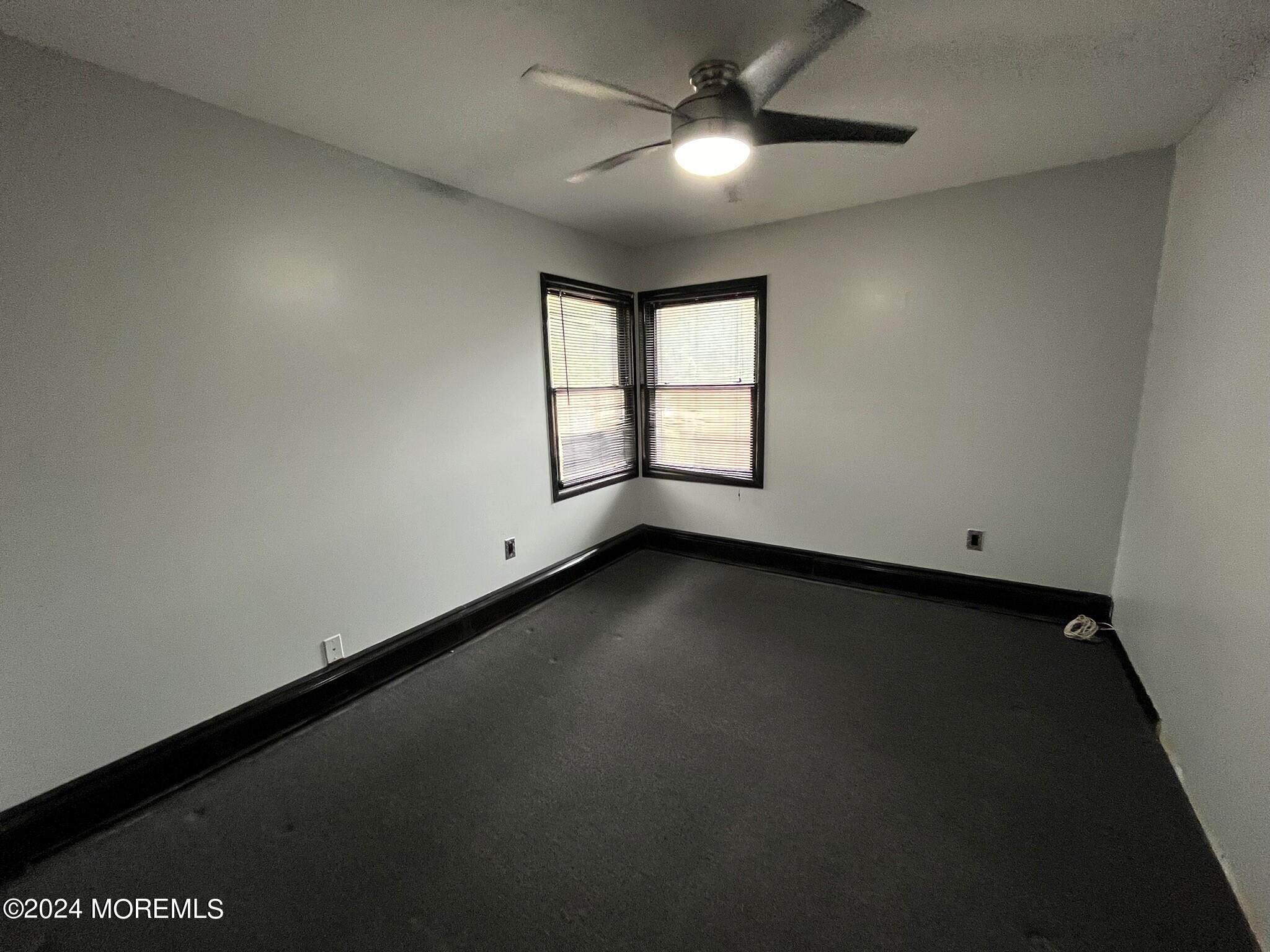 189 Tennent Road Morganville, NJ 07751 - Photo 29 of 45 an empty room with a window and a ceiling fan