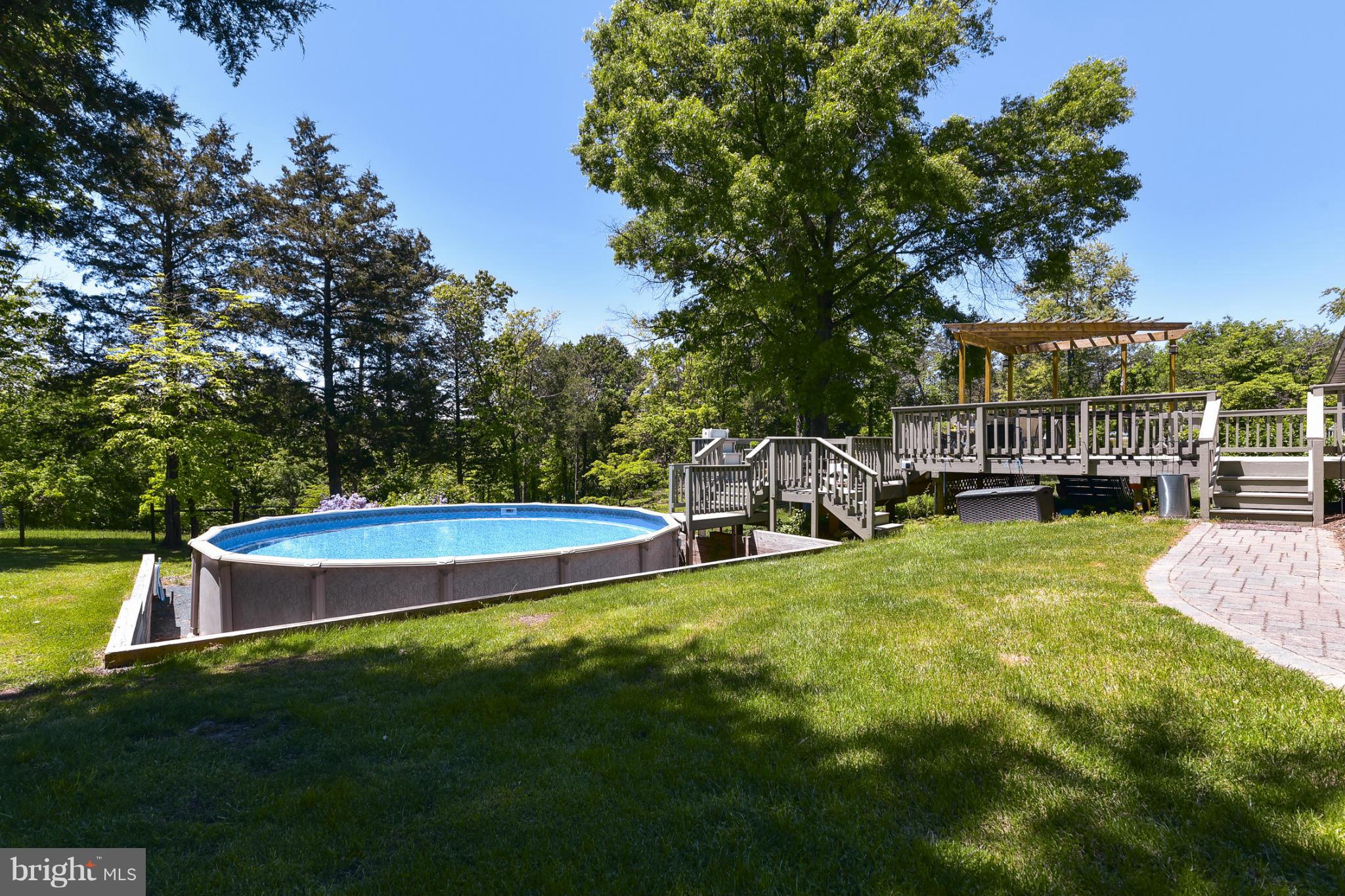 8033 Waterloo Farm Road Warrenton, VA 20186 - Photo 25 of 30 a view of a swimming pool with a bench and trees around