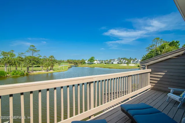 a view of a swimming pool with a yard and palm trees