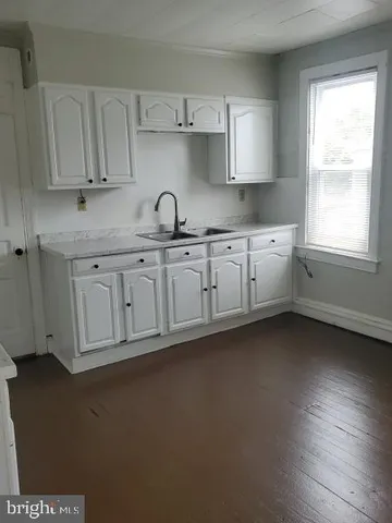 a kitchen with stainless steel appliances granite countertop a sink cabinets and wooden floor
