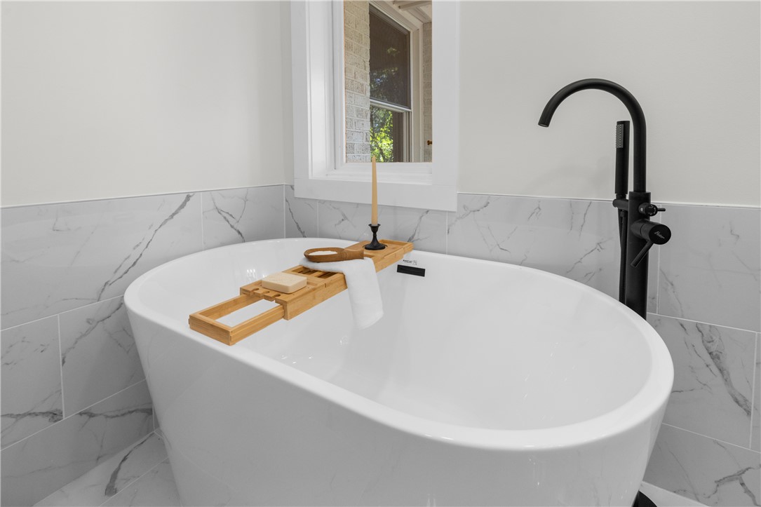 251 Riggs Drive Clemson, SC 29631 - Photo 25 of 37 An elegant soaking tub highlights the bathroom with modern matte black hardware and marble tile surrounds.
