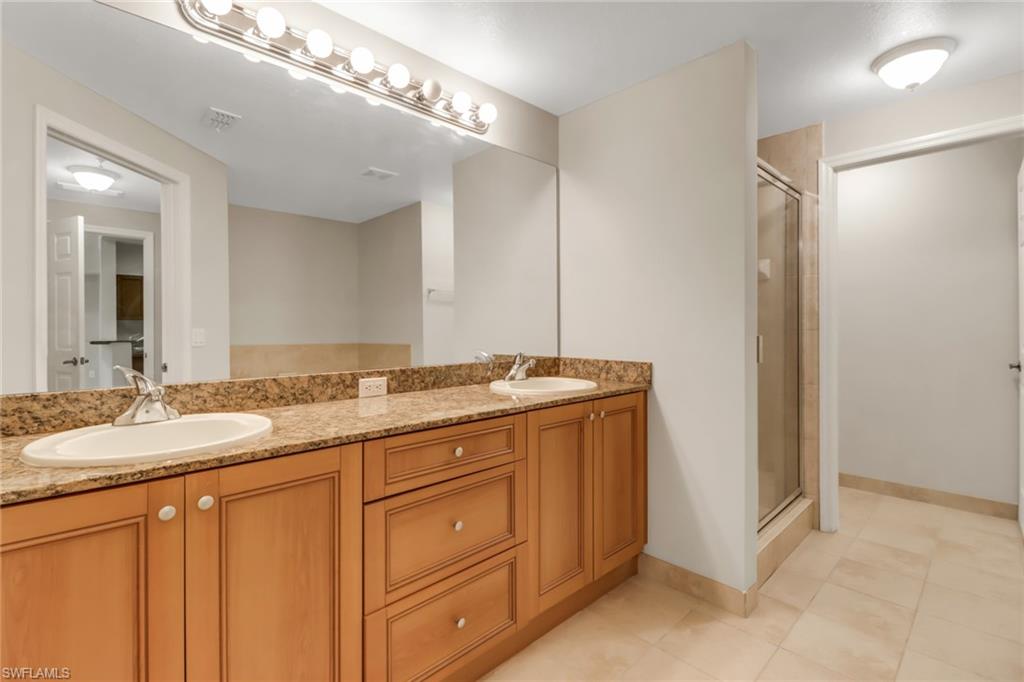 20160 Estero Gardens Circle, Unit 202 Estero, FL 33928 - Photo 16 of 44 a bathroom with a granite countertop sink and a mirror
