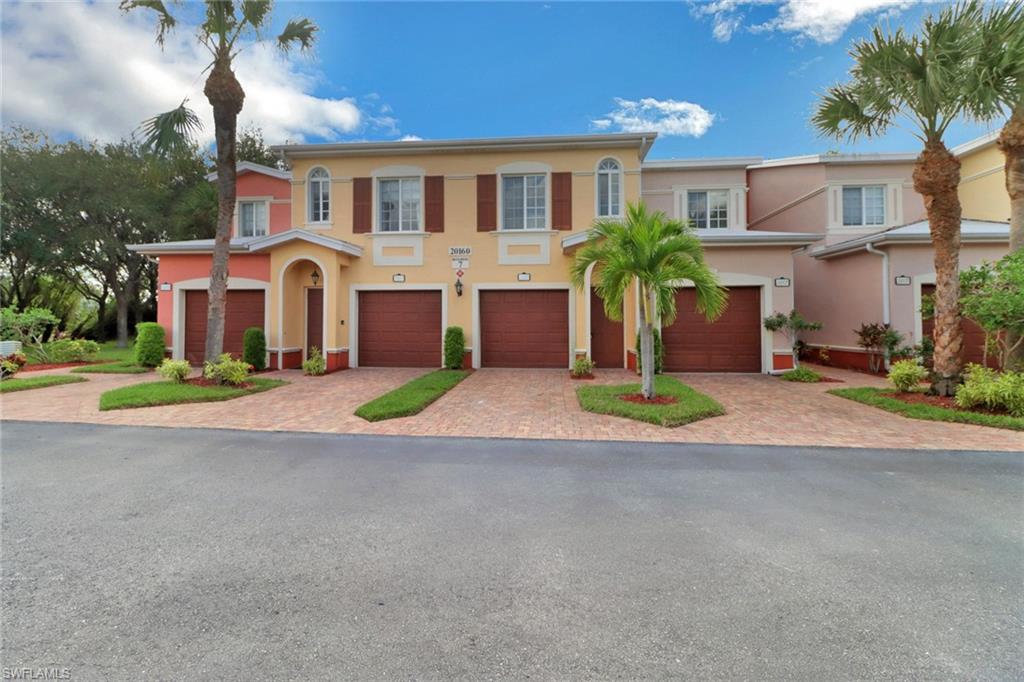 20160 Estero Gardens Circle, Unit 202 Estero, FL 33928 - Photo 2 of 44 a front view of house with yard and trees