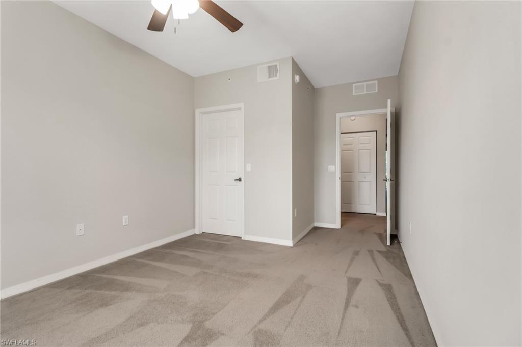 20160 Estero Gardens Circle, Unit 202 Estero, FL 33928 - Photo 23 of 44 an empty room with chandelier fan and closet